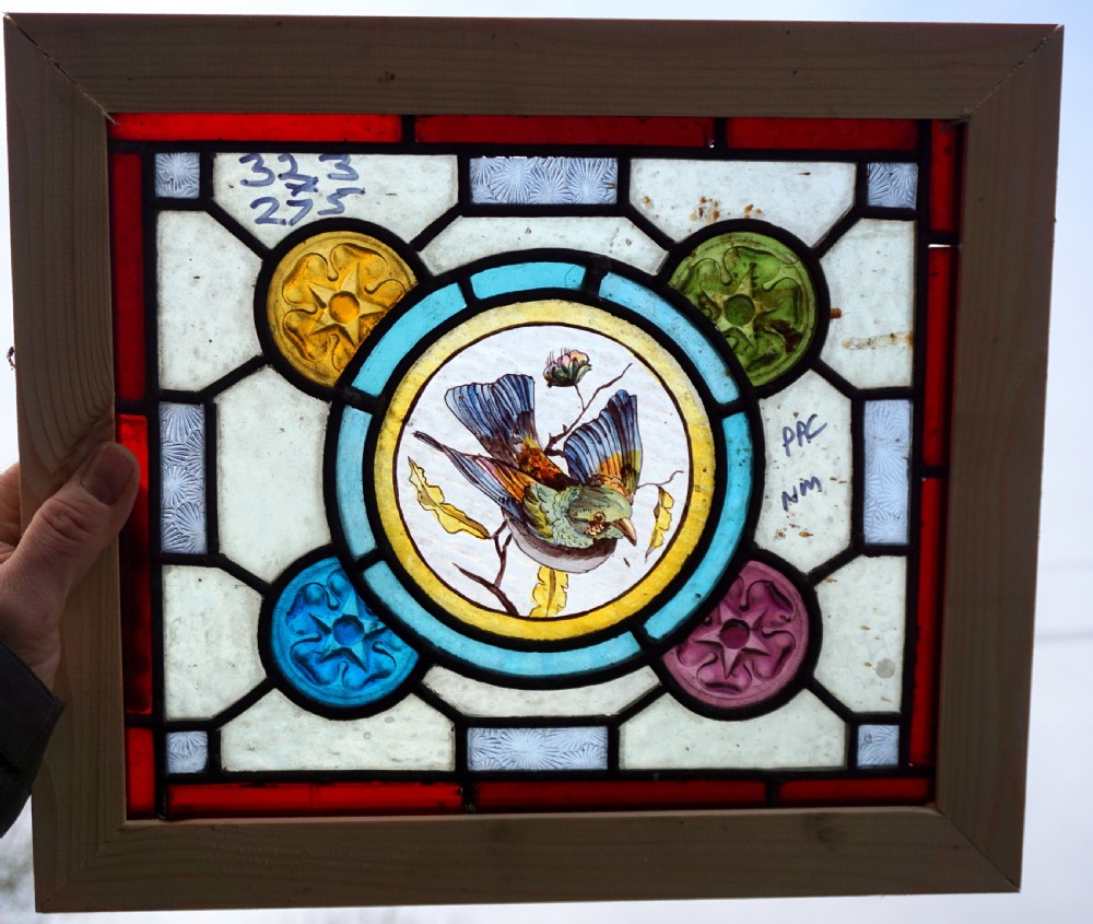 a great stained glass painted window with painted bird centre